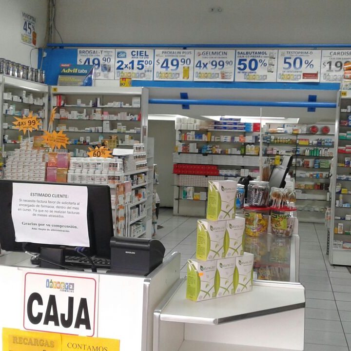 Caja y área de entrega de insumos con anaqueles de medicamentos