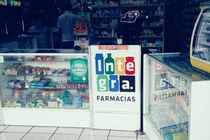 Mostrador con el logotipo de Farmacias Integra y vitrinas de medicamento
