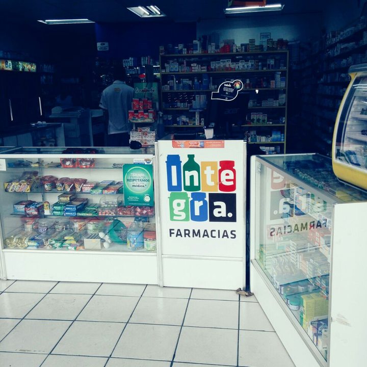Mostrador con el logotipo de Farmacias Integra y vitrinas de medicamento
