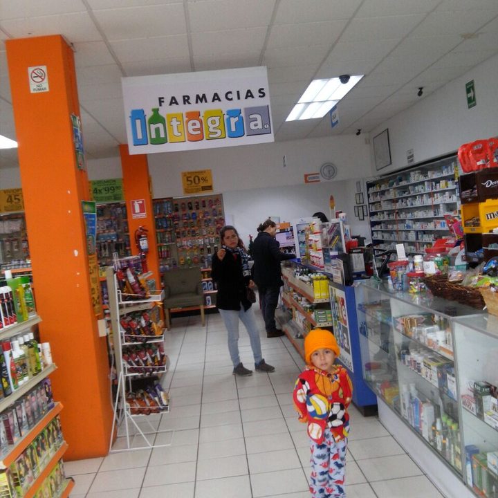 Pasillo de una sucursal con anaqueles de cuidado personal y columnas naranjas