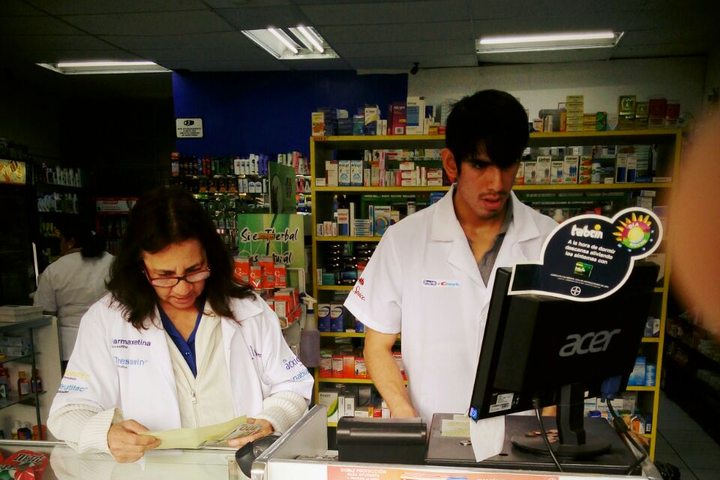 Personal de Farmacias Integra con bata blanca atendiendo en el mostrador