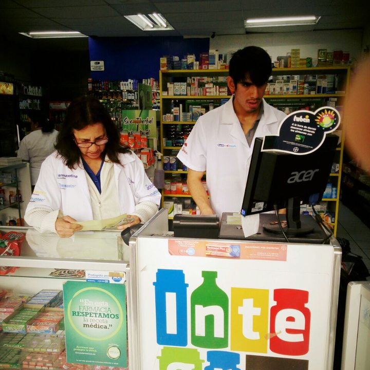 Personal de Farmacias Integra con bata blanca atendiendo en el mostrador